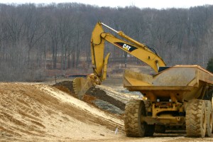 Builders trip, stockpile and compact soil.