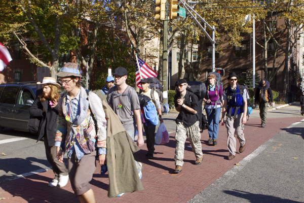 protesters march up Grand Steeet, with police escort